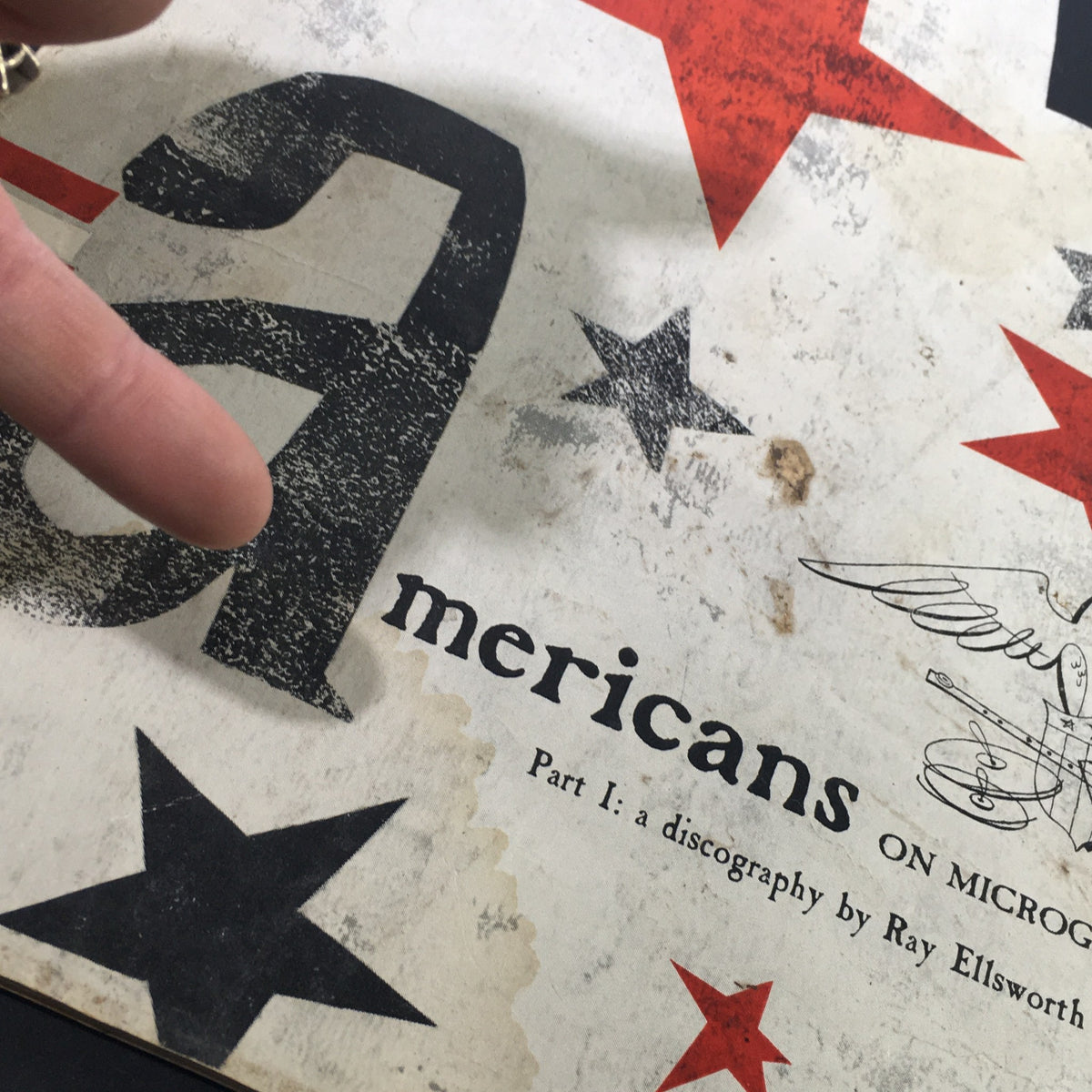 Detailed view of the cover of VTG High Fidelity Music Magazine July 1956, focusing on the title 'Americans on Microgroove Part I' and decorative graphics.