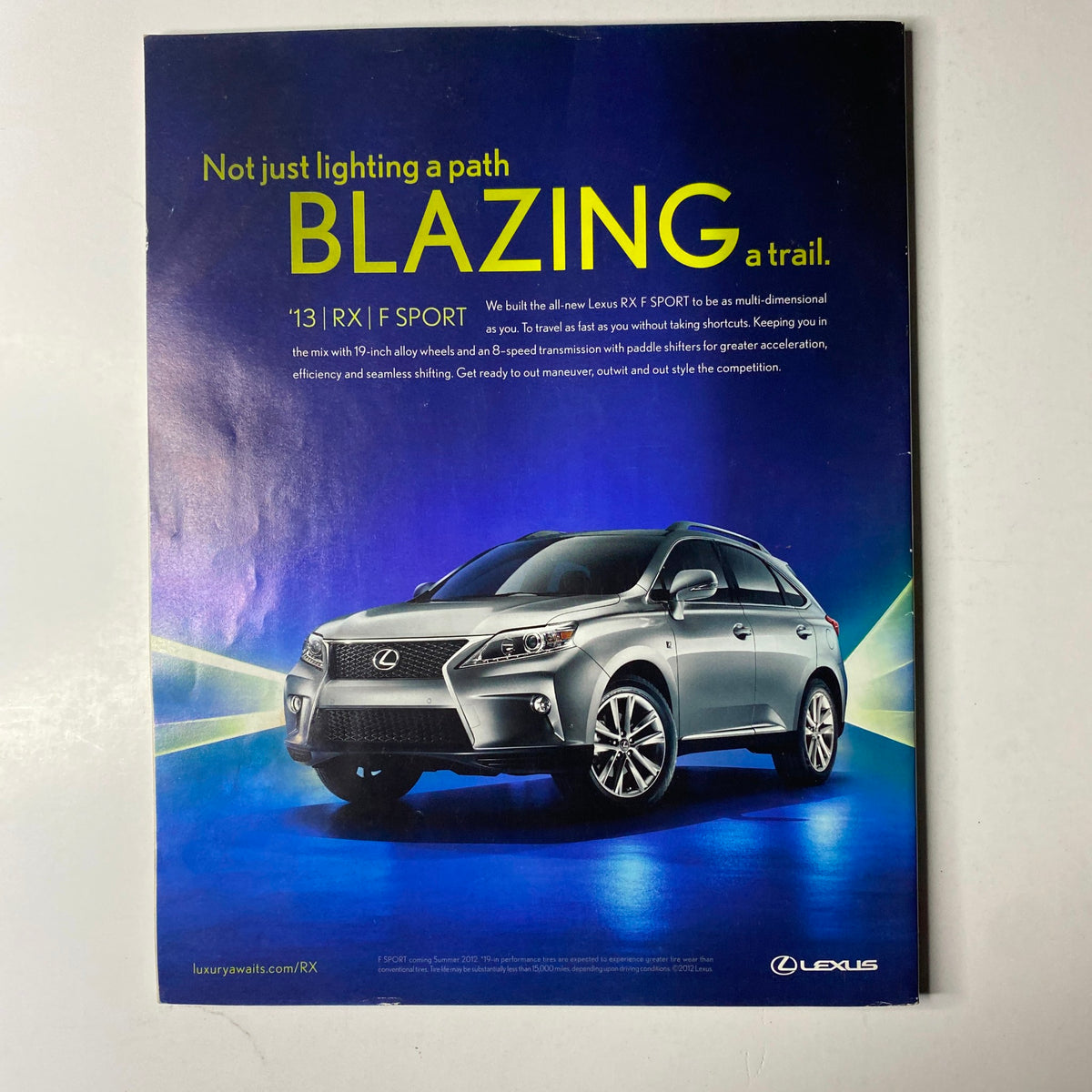 Advertisement for Lexus in Ebony Magazine July 2012, highlighting the 2013 RX model with a focus on luxury and performance.