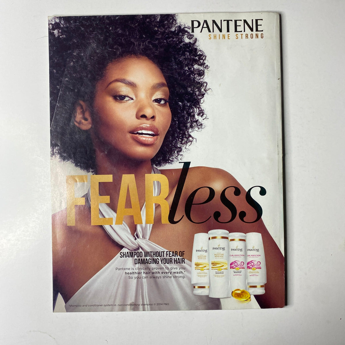 Pantene advertisement featuring a model with beautiful, curly hair, promoting the Shine Strong line with the tagline 'FEARless' in Ebony Magazine November 2014, Vol. LXX, No. 1.