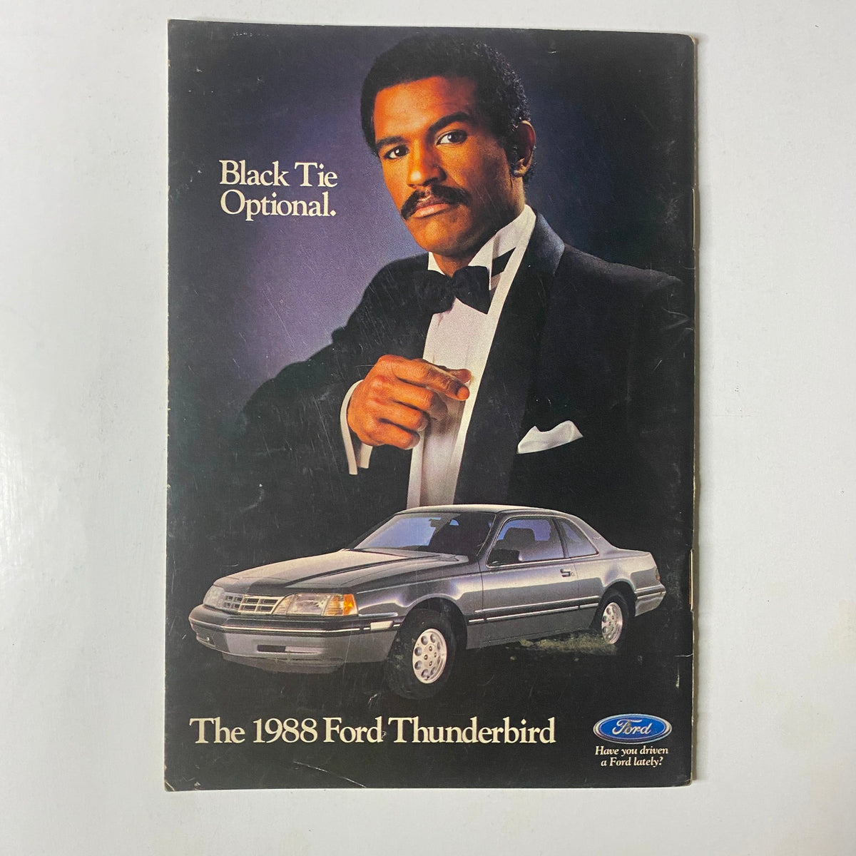 Cover of the 1988 Ford Thunderbird advertisement featuring a man in a tuxedo with the tagline 'Black Tie Optional', promoting the luxury features of the vehicle.