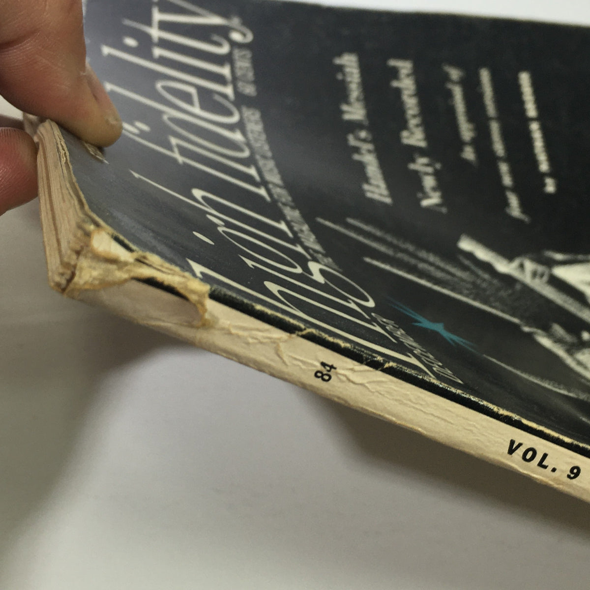 Close-up view of the edge of the VTG High Fidelity Music Magazine from December 1959, showcasing minor wear and tear, including creases and fraying, indicative of its vintage condition.