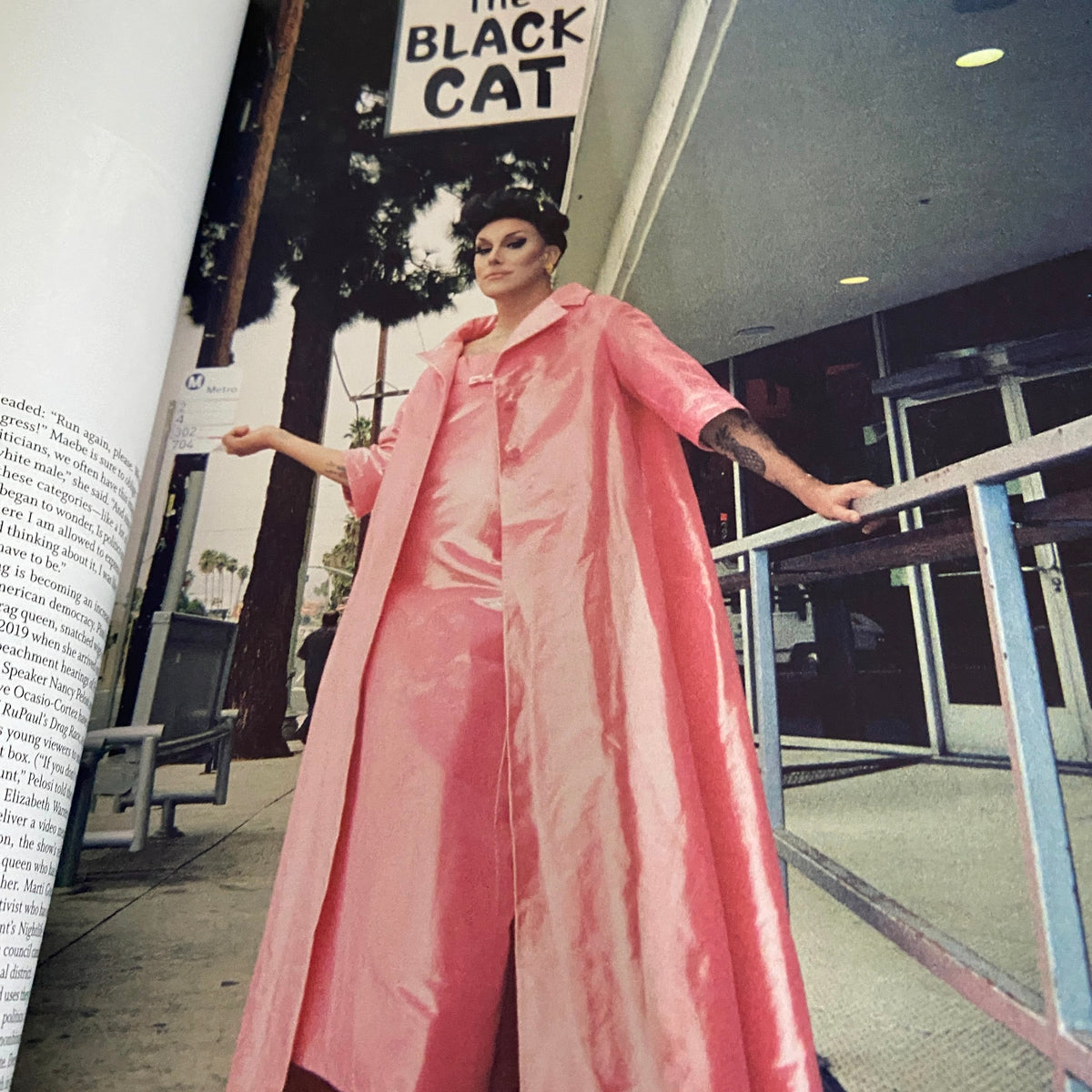 A fashion editorial image from W Magazine 2020 Volume 4 showcasing a model in a striking pink outfit outside 'The Black Cat', embodying contemporary style innovations.