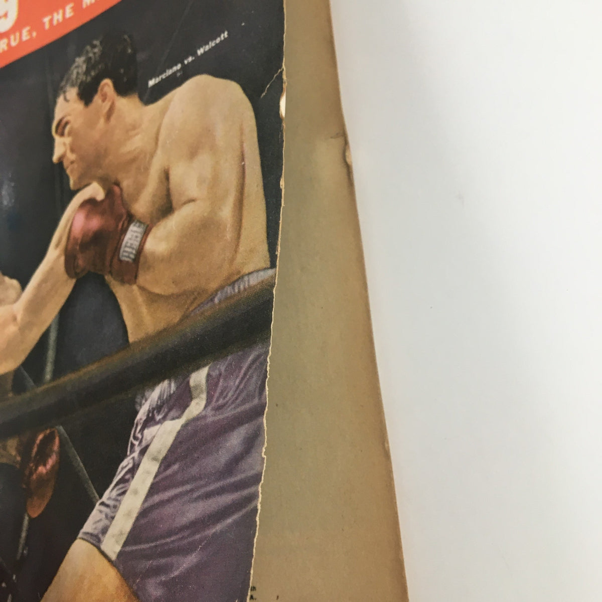 Close-up of the edge of the Boxing Yearbook Magazine 1953, focusing on the cover featuring Rocky Marciano, showcasing wear characteristic of vintage collectibles.