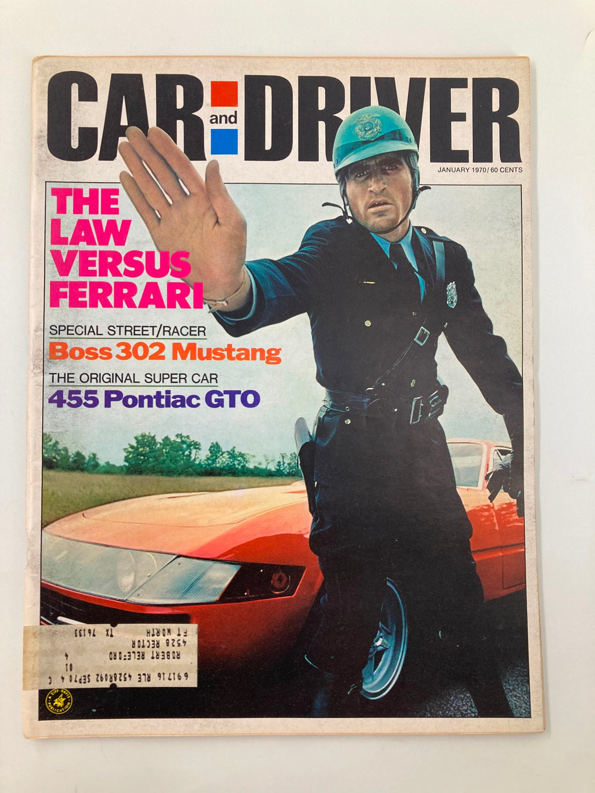 Cover of Car and Driver Magazine January 1970 featuring the title 'The Law Versus Ferrari' with a police officer gesturing and a red sports car in the background. This issue includes features on the Boss 302 Mustang and 455 Pontiac GTO.