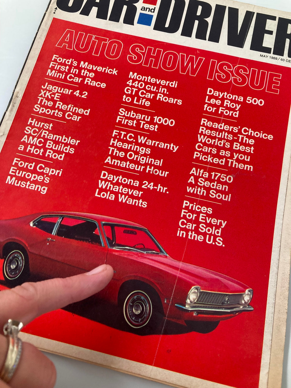 Close-up of the cover of Vintage Car and Driver Magazine May 1969 pointing at the Ford Maverick featured in the AUTO SHOW ISSUE with articles on various automobile brands.