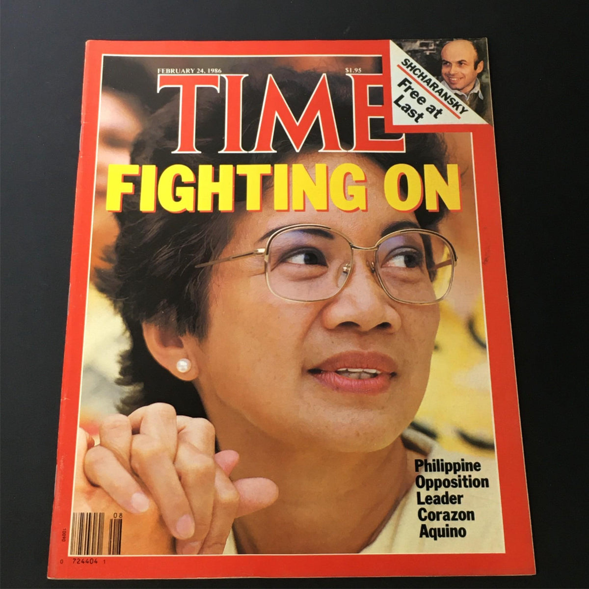 Vintage Time Magazine cover from February 24, 1986, featuring Philippine opposition leader Corazon Aquino with the title 'Fighting On'. This collectible magazine illustrates Aquino's role in the fight for democracy and political change in the Philippines.