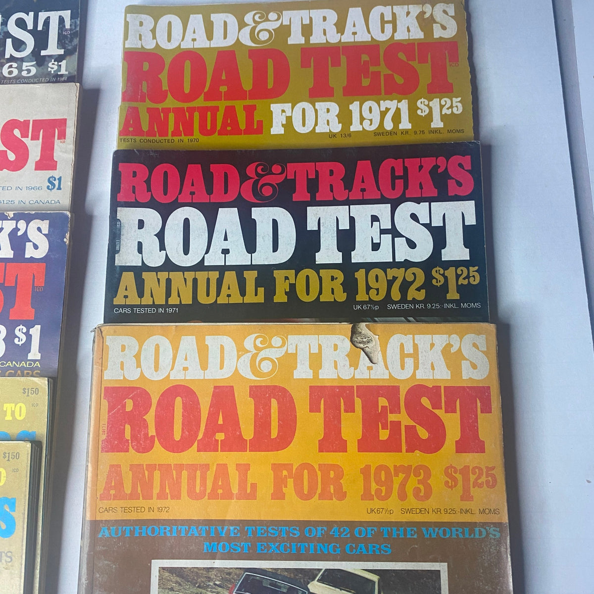 Collection of Road & Track Road Test Annuals from 1971, 1972, and 1973, part of a lot of 8 magazines featuring classic car reviews.
