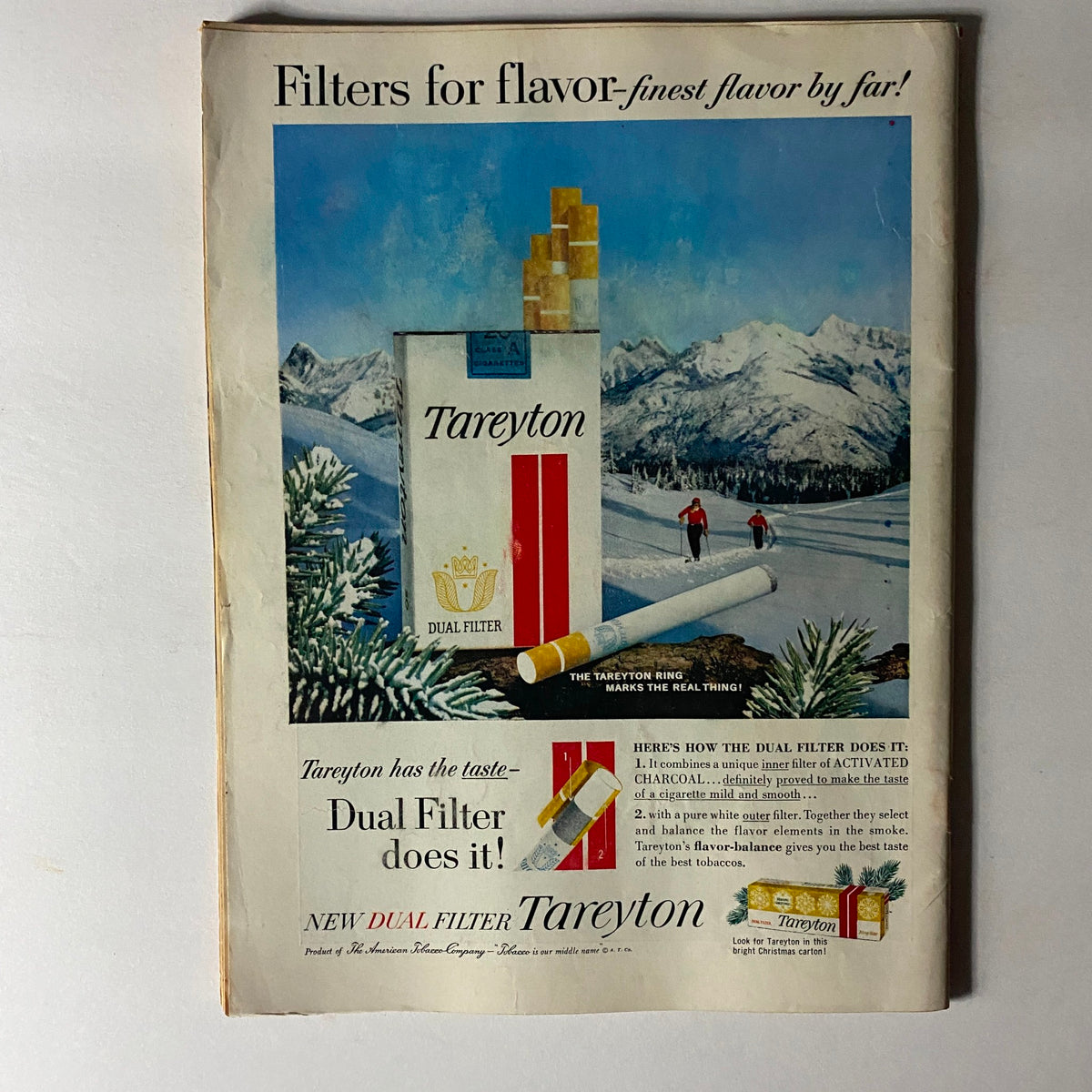 Vintage advertisement for Tareyton cigarettes, highlighting the dual filter technology amidst a scenic snowy mountain background.