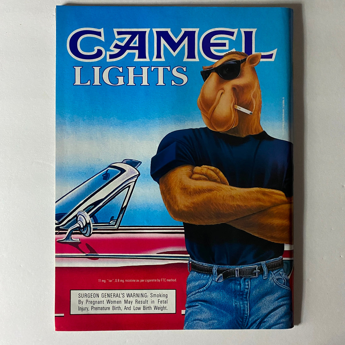 Cover of Camel Lights advertisement featuring a cartoon camel character with sunglasses and a cigarette leaning against a car.