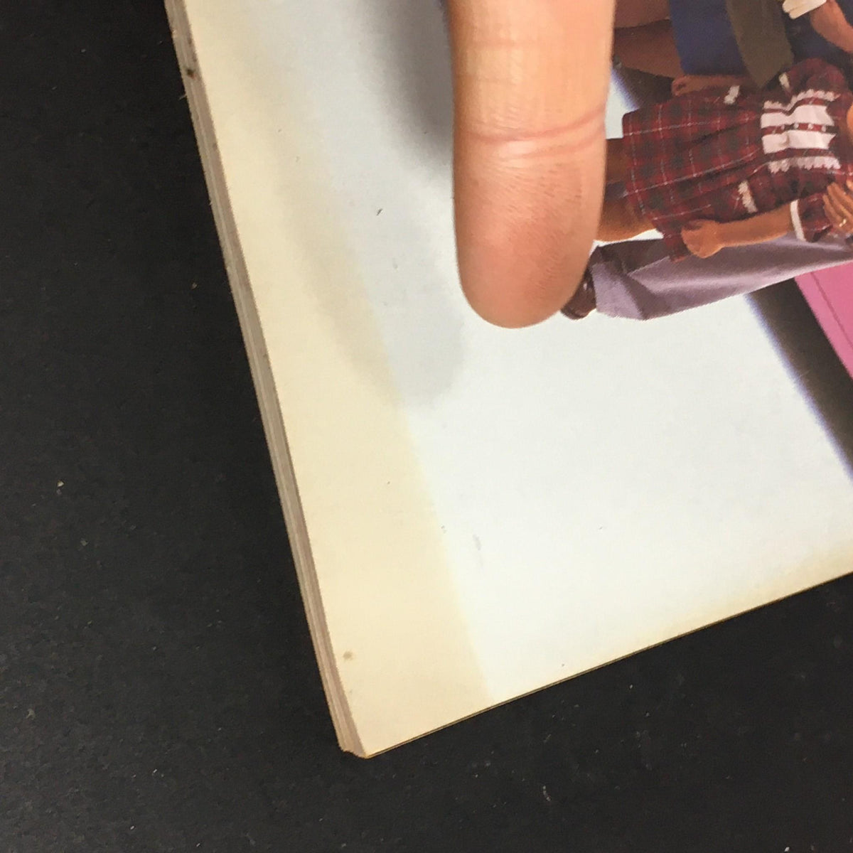 Close-up of a finger pointing at the edge of a vintage Fortune Magazine, September 14, 1987 issue featuring articles on Apple and Perelman's Revlon.
