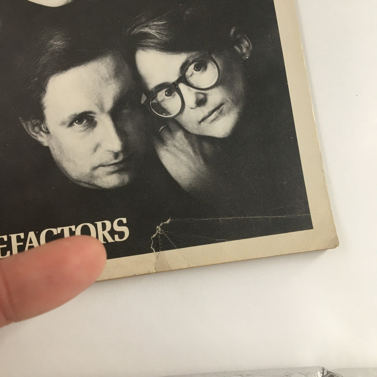 Close-up of the 1986 Playbill for Benefactors, highlighting characters' faces with a focus on vintage aesthetic details.
