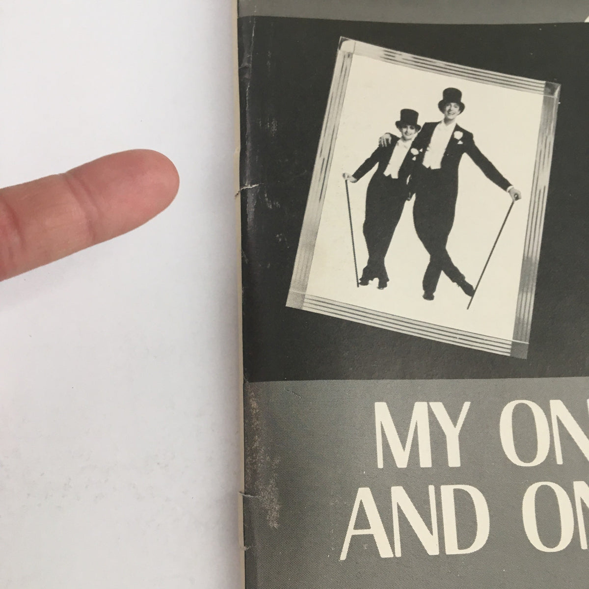 Close-up of the 1983 Playbill for My One and Only showing the prominent title and a finger pointing at it, showcasing its classic design.