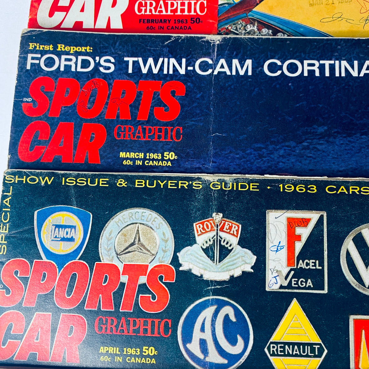 Lot of 9 Sports Car Graphic Magazine 1963 February - September, November highlighting the March 1963 issue with Ford's Twin-Cam Cortina and various car logos.