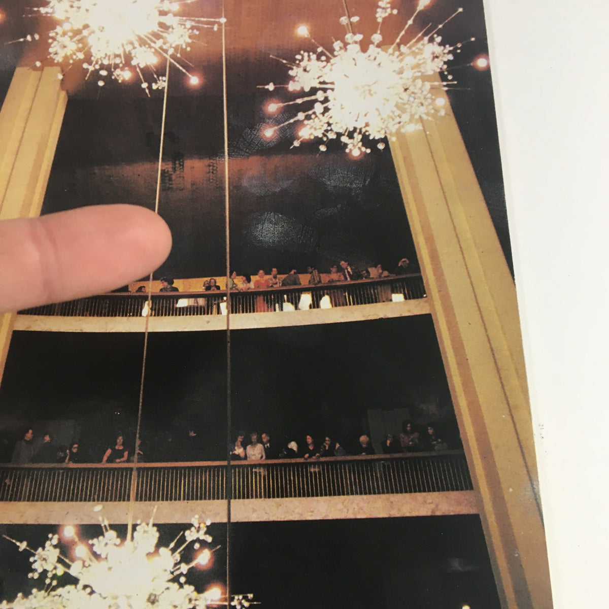 Close-up view of audience members in the 1985 Lincoln Center Stagebill for Metropolitan Opera, highlighting the elegant setting with chandeliers.