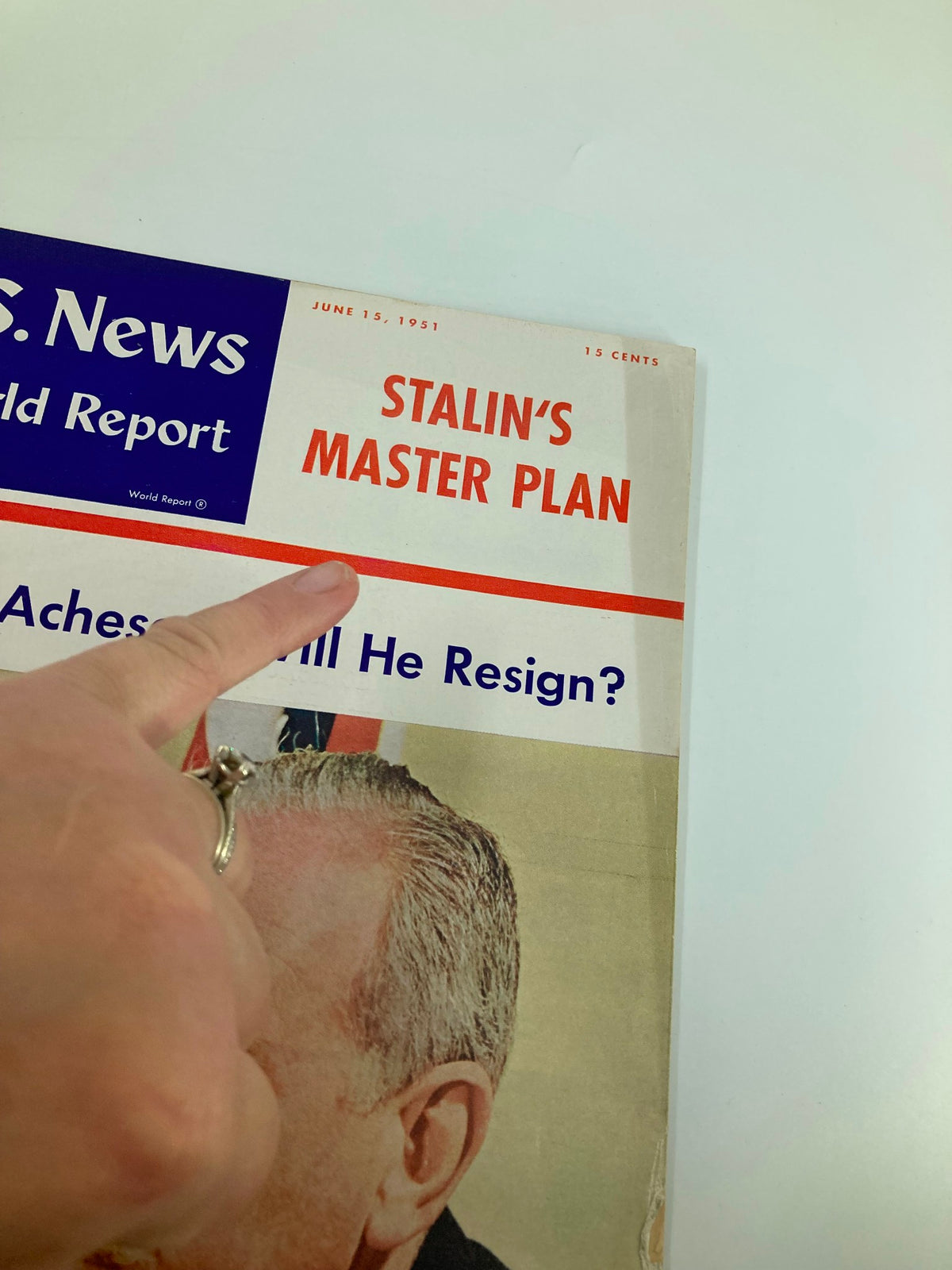 Close-up of the cover of US News & World Report Magazine from June 15, 1951, with a finger pointing at the headline 'Acheson: Will He Resign?' showcasing Dean Acheson, Secretary of State.