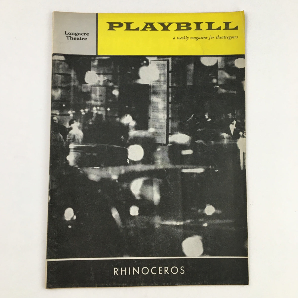 1961 Playbill Longacre Theatre showcasing Eli Wallach in Ionesco's Rhinoceros with artistic cover design featuring blurred city lights.