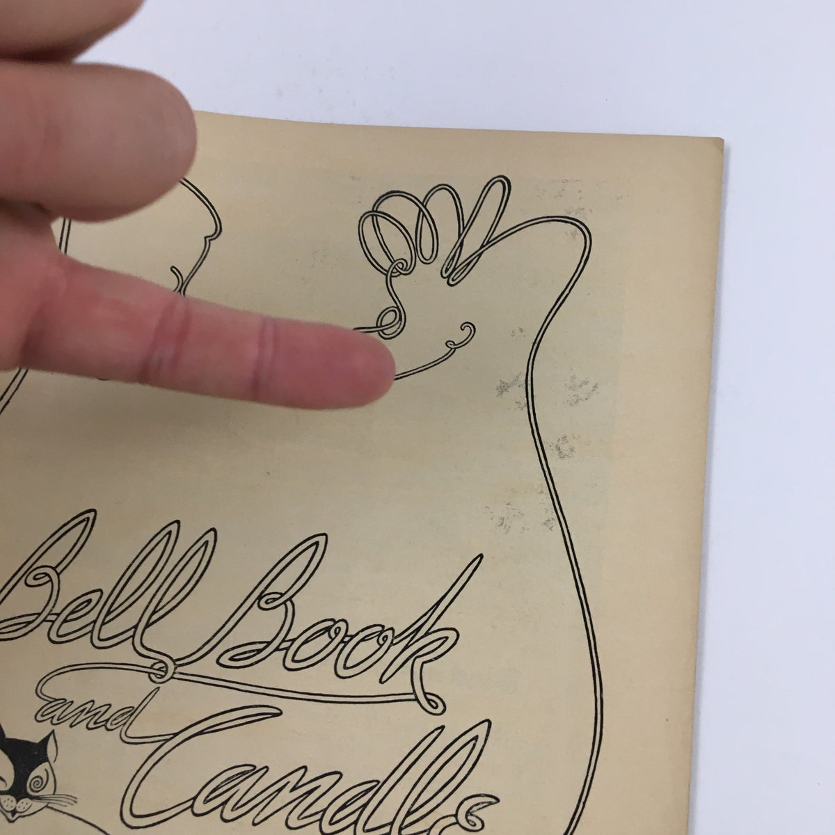 Close-up of the cover of the 1950 Playbill for 'Bell, Book and Candle' featuring a decorative hand illustration and text details.