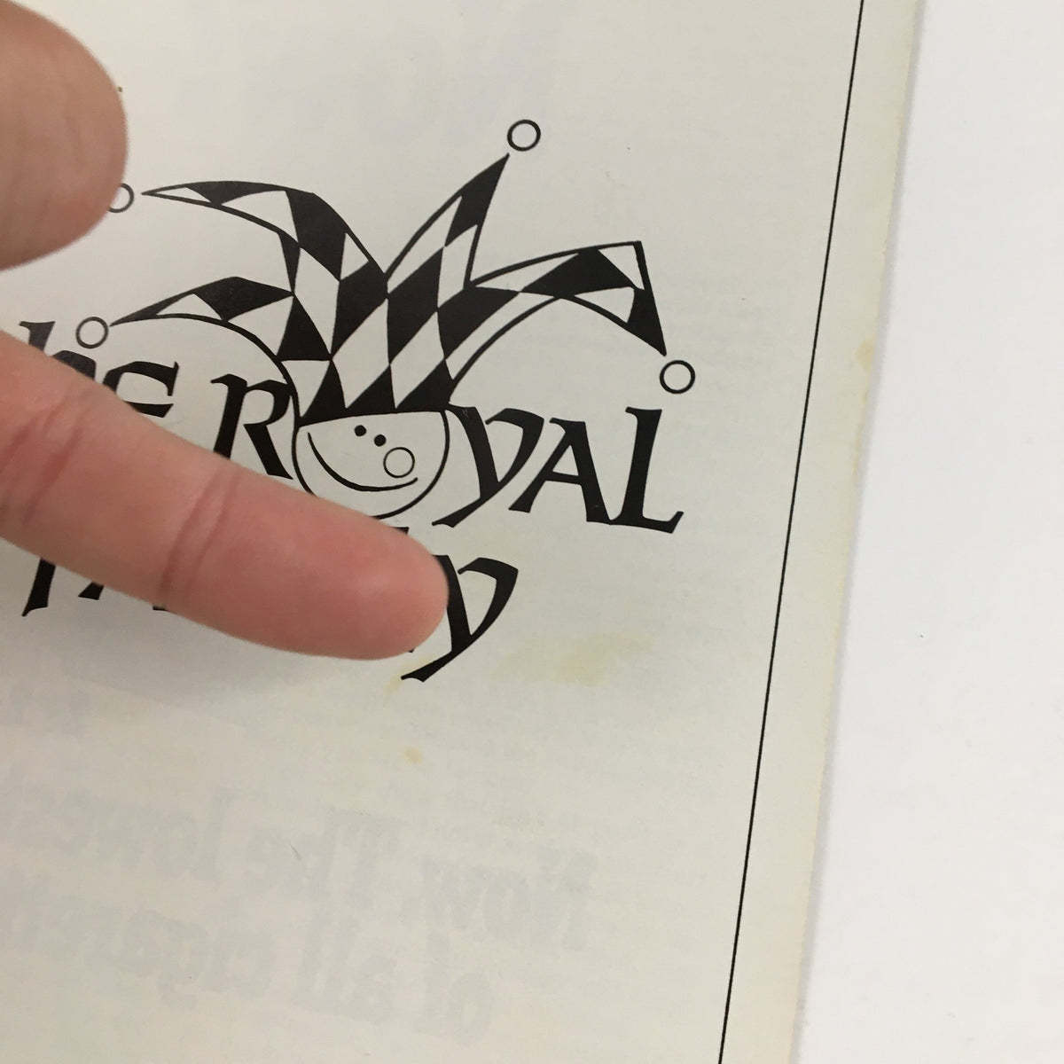 Close-up of the 1976 Playbill for The Royal Family showing the jester logo and a finger pointing at the title.