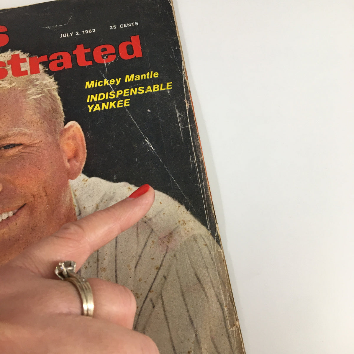 Close-up of the July 2, 1962 Sports Illustrated magazine featuring Mickey Mantle with the text 'Indispensable Yankee'. The cover shows wear and minor creases, emphasizing its vintage nature.