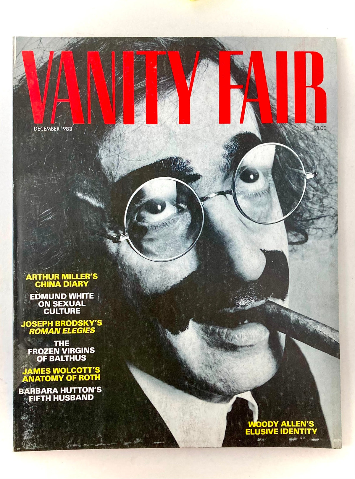 Vintage December 1983 Vanity Fair Magazine featuring an article on Woody Allen's elusive identity, showcasing a bold cover with prominent red text and an intriguing photograph.