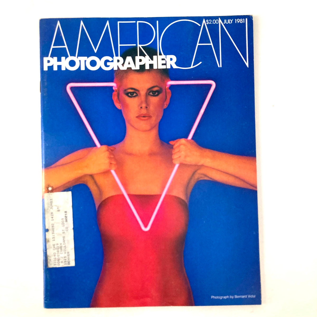 Cover of the American Photographer Magazine from July 1981 featuring model Susan Angst, highlighting an edgy visual theme with neon colors and geometric shapes, emphasizing the photographic artistry of the era.