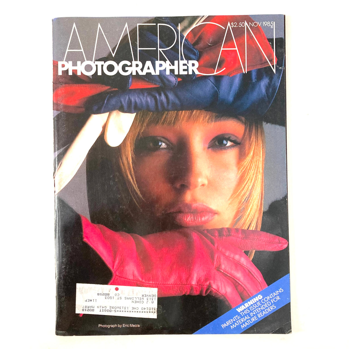 Cover of the November 1985 issue of American Photographer Magazine featuring a striking model with a colorful hat and gloves, highlighting a profile of photographer Joel-Peter Witkin.