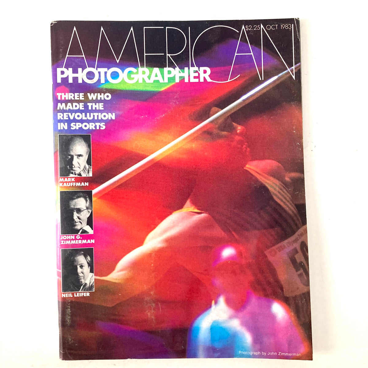 Cover of American Photographer Magazine October 1983 featuring a vibrant design with a javelin thrower, highlighting the theme of sports photography.
