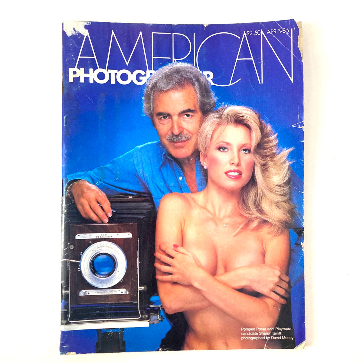 Cover of the American Photographer Magazine April 1985 featuring photographers Pompeo Posar and Sharon Smith with a vintage camera, highlighting the era's photography style.