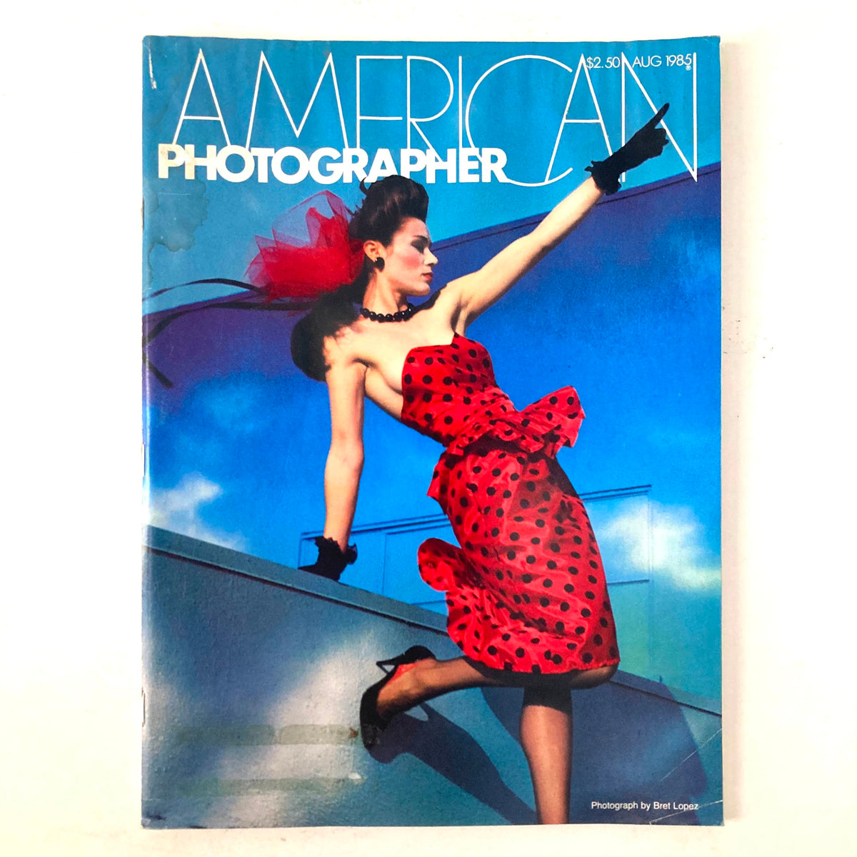 American Photographer Magazine August 1985 featuring a striking cover image of a model in a polka dot dress. The magazine showcases 'Soleful Shots of Thom McAn Shoes,' blending fashion and photography.