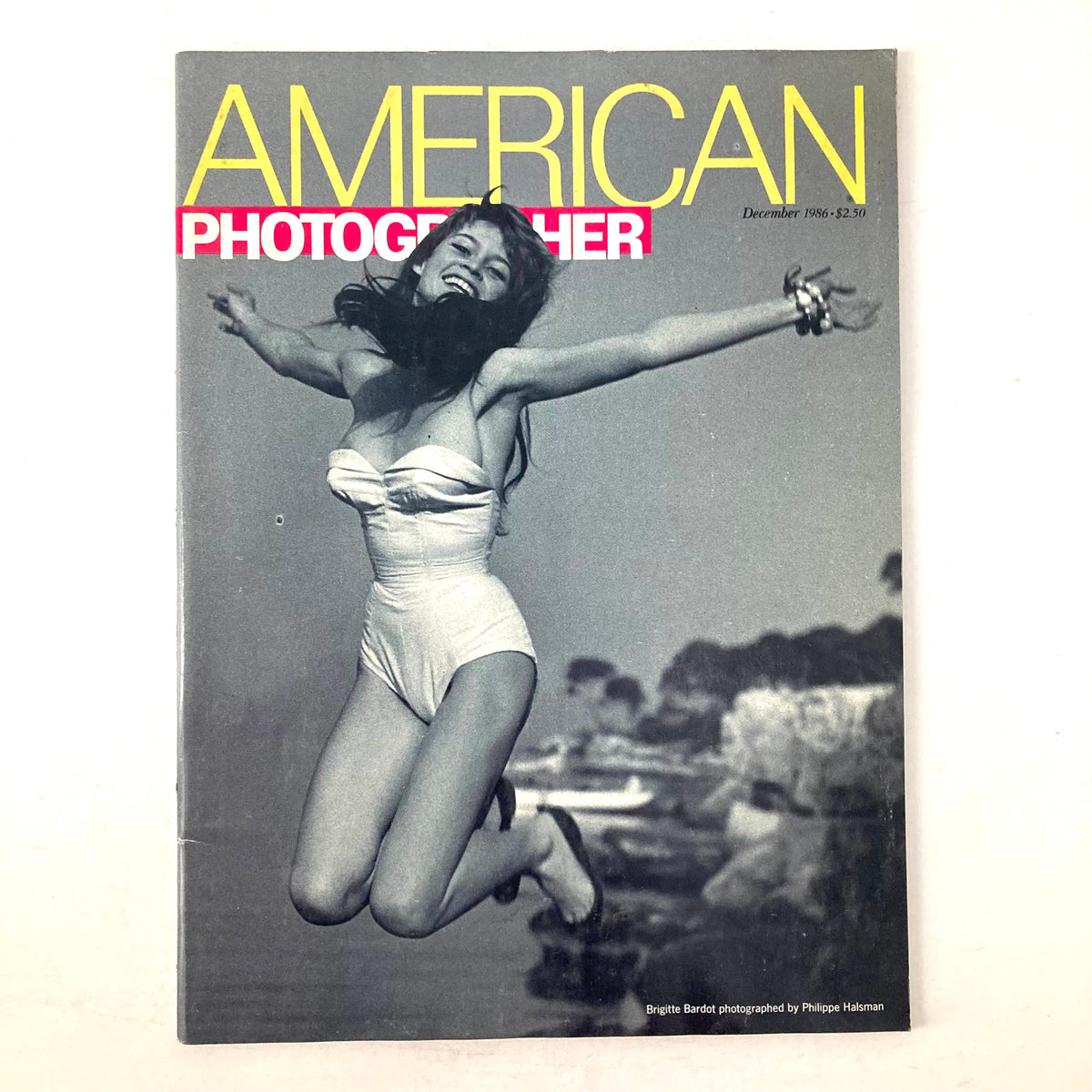 American Photographer Magazine December 1986 featuring Brigitte Bardot on the cover, showcasing her iconic pose in a white swimsuit against a vintage backdrop.