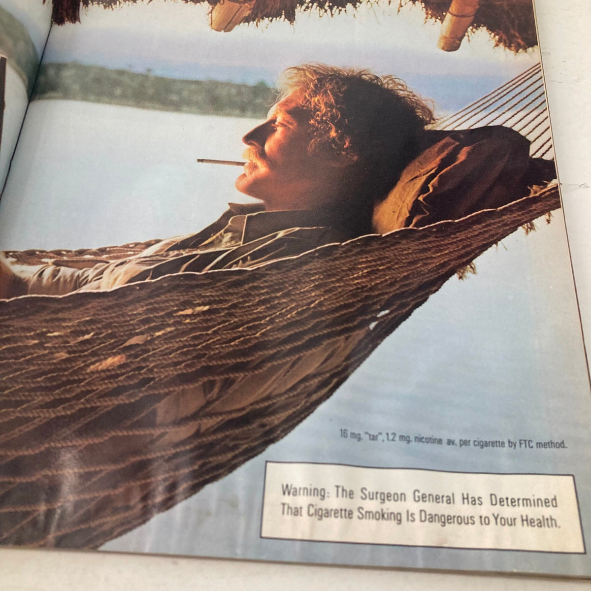 Image from American Photographer Magazine March 1985 featuring a man relaxing in a hammock with a cigarette, emphasizing lifestyle and leisure.