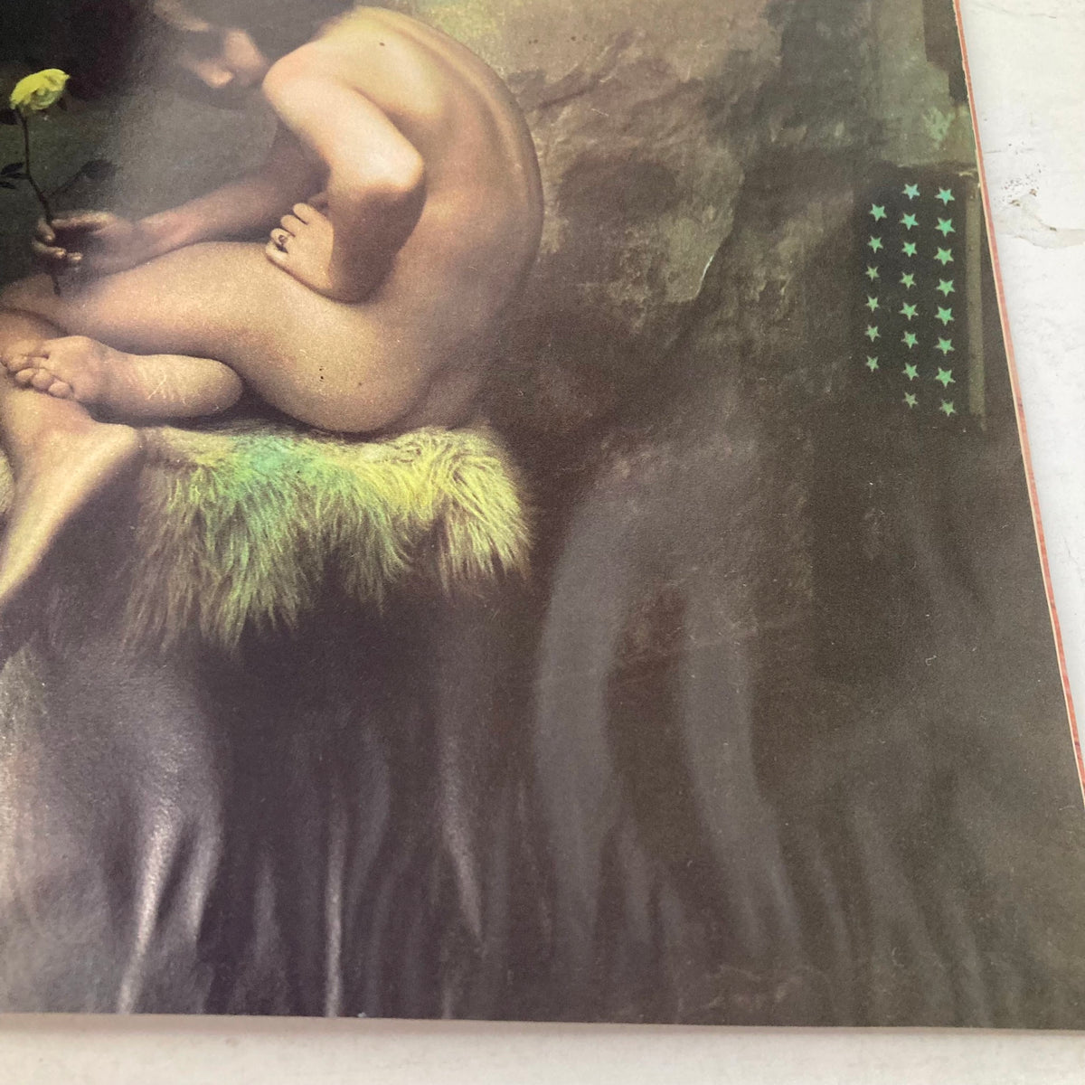 Artistic depiction from American Photographer Magazine March 1985 showing a nude child holding a flower, blending innocence and nature.