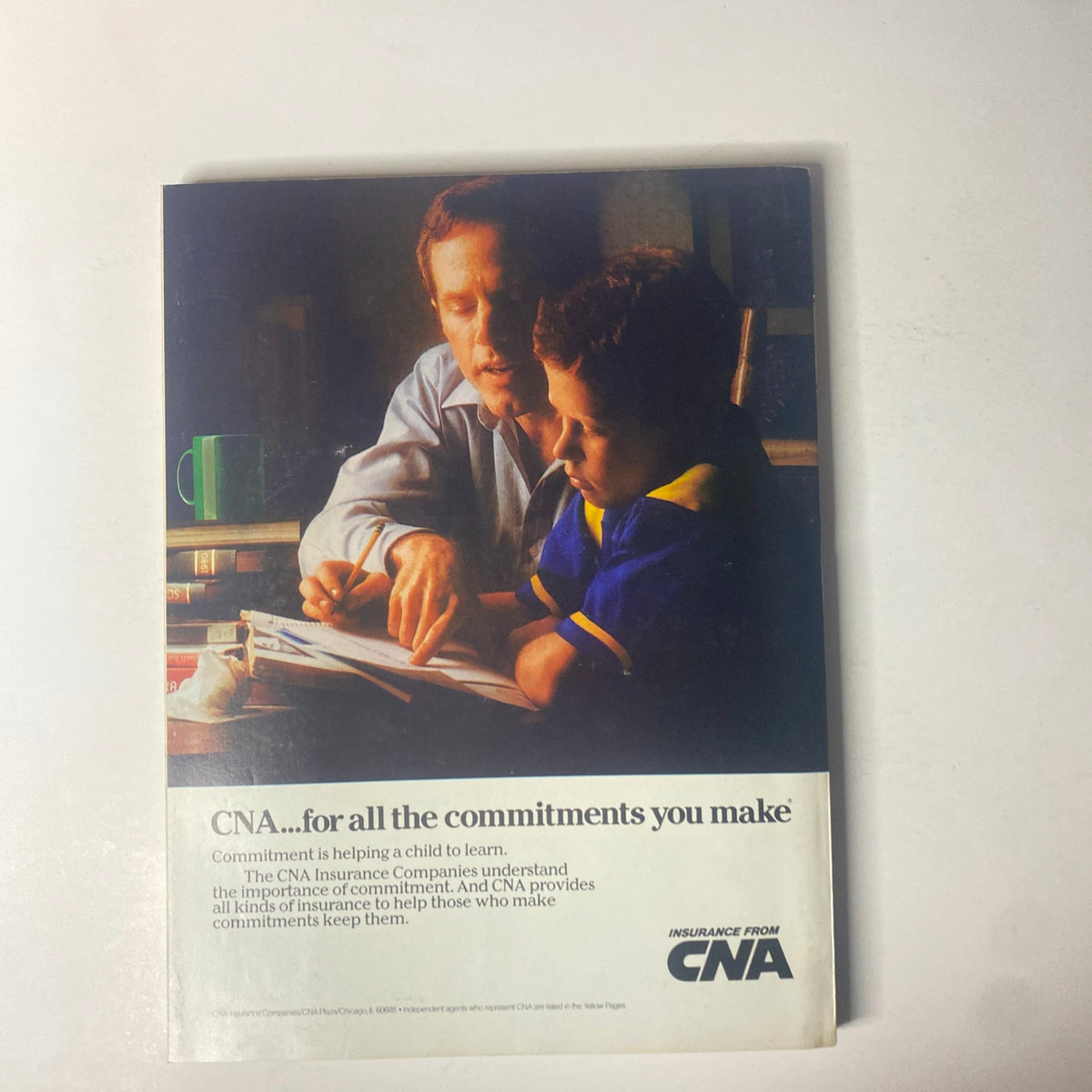 Advertisement from Forbes Magazine 1987 for CNA Insurance, emphasizing the concept of commitment through a memorable image of a father and son studying together.
