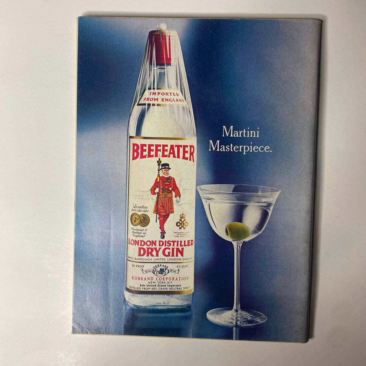 Vintage advertisement for Beefeater London Distilled Dry Gin featuring a bottle and a martini glass with an olive. Part of the issue of Forbes Magazine November 15, 1977, titled 'Foreign Trade: Who's Helped? Who's Hurt?'. This ad highlights the iconic gin brand suitable for cocktail enthusiasts.