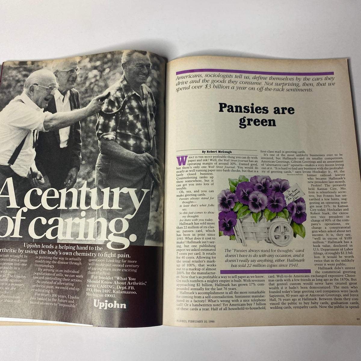 Forbes Magazine February 10, 1986, featuring an article on the greeting card business with vintage images of men discussing agriculture and a flower illustration, highlighting emotional marketing in the $3 billion industry.