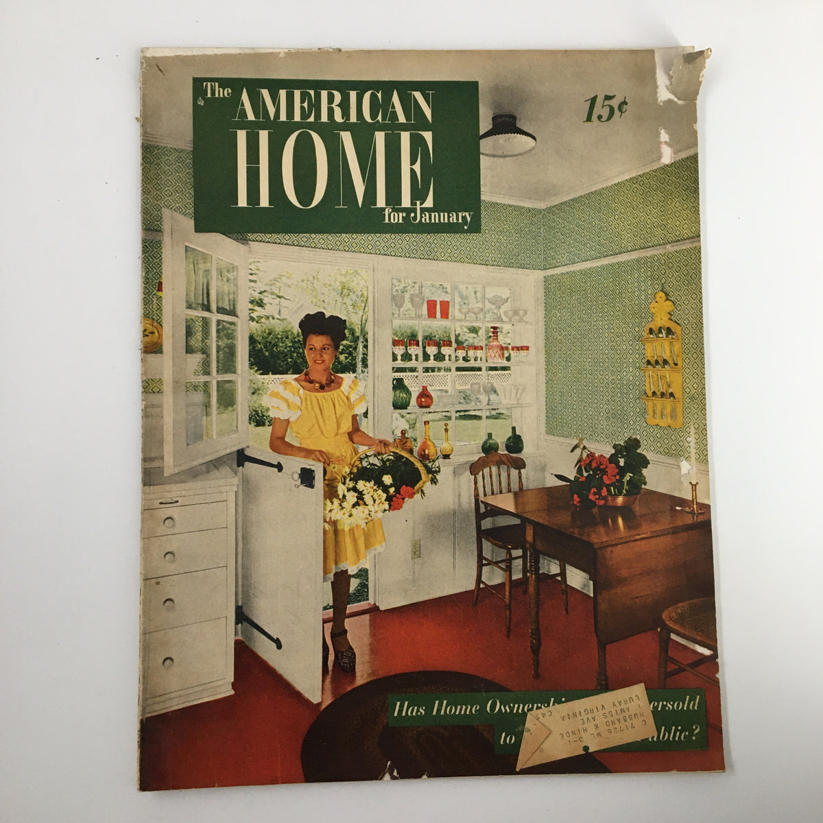 Cover of VTG The American Home Magazine January 1947 featuring a woman in a yellow dress holding flowers in a kitchen scene with vintage decor.