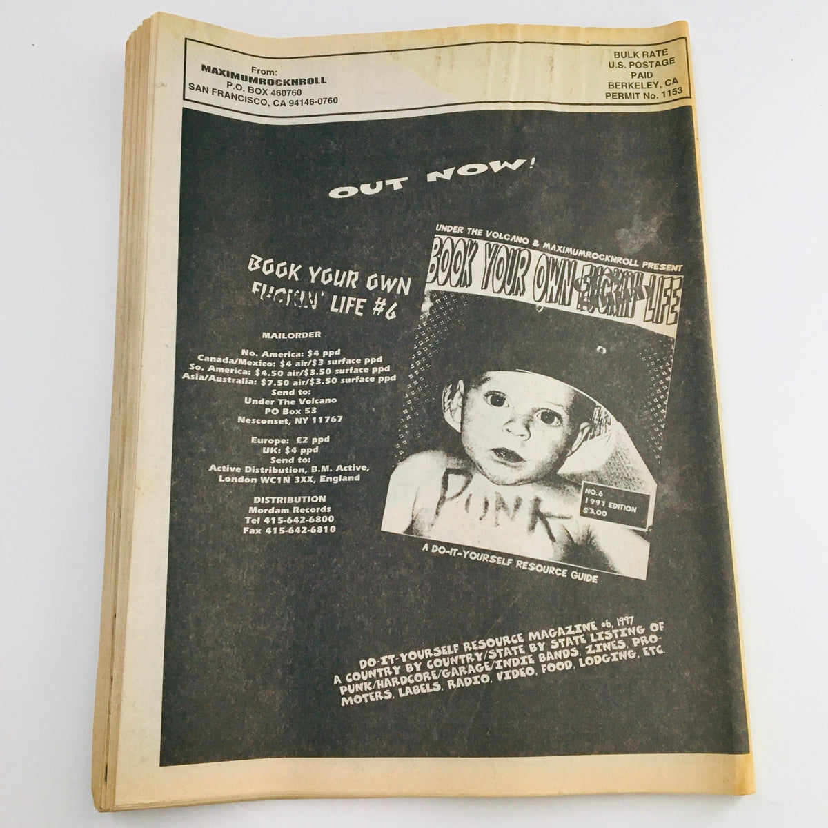 Promotional page from Maximum RocknRoll Magazine May 1997 #168 advertising 'Book Your Own Fuckin Life #6', emphasizing its DIY punk resource guide.