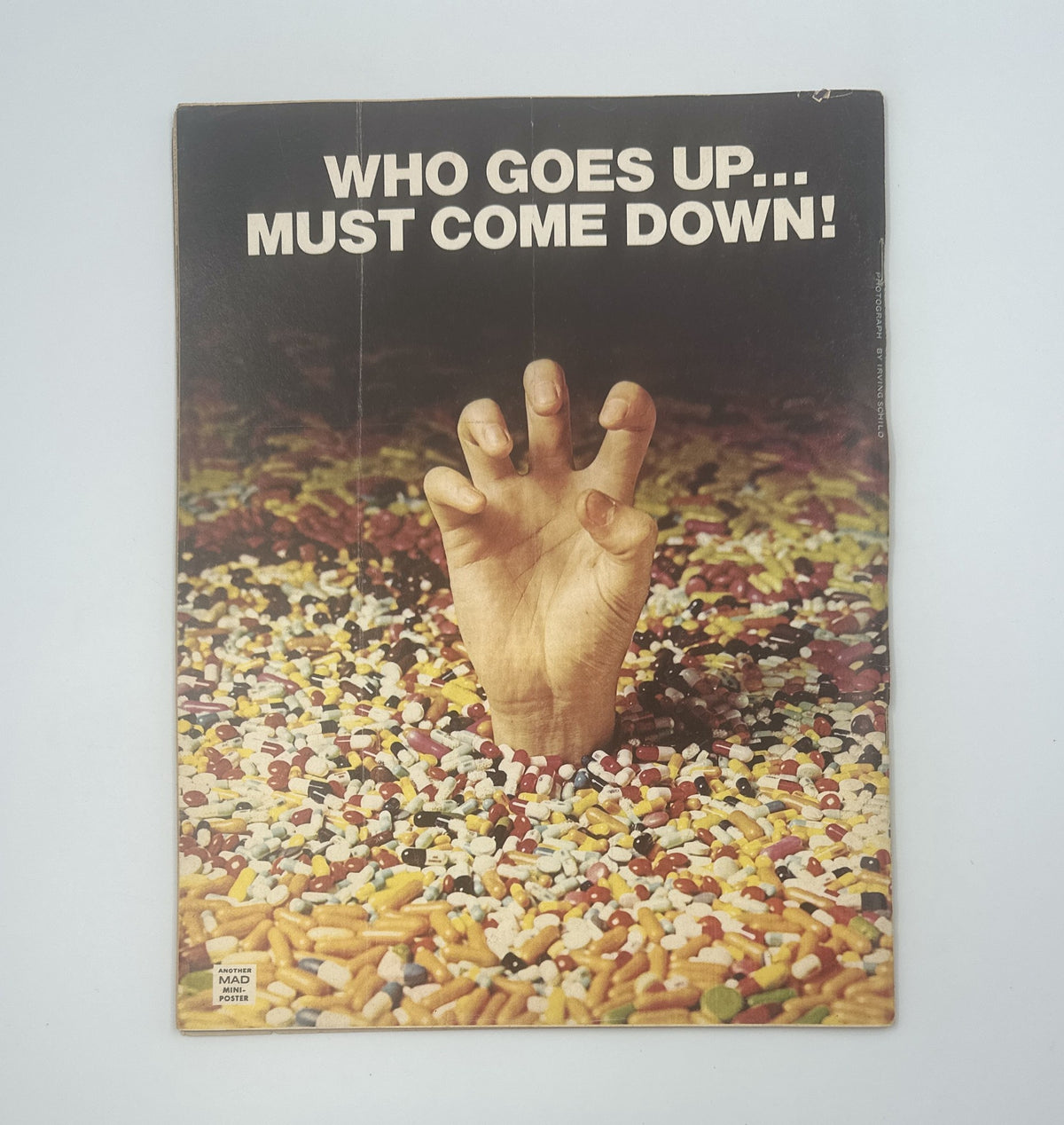 Back cover of MAD Magazine No. 173 from March 1975, illustrating a hand breaking through colorful candy and pills with the caption 'Who Goes Up... Must Come Down!'.