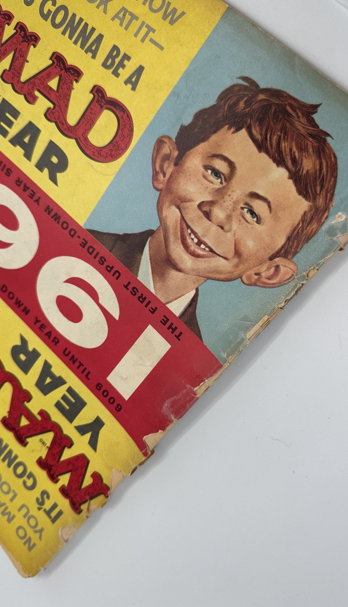 Close-up of the cover art of MAD Magazine #61 from March 1961 showcasing a smiling child character and vibrant colors promoting 'It's Gonna Be a MAD Year'.