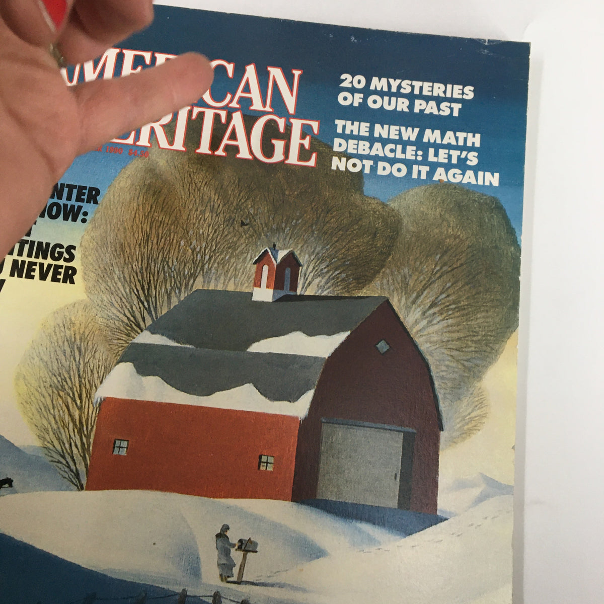 Close-up of the cover of American Heritage Magazine December 1990 displaying the title 'Great Paintings You Never Saw' with a red barn in a snowy setting.