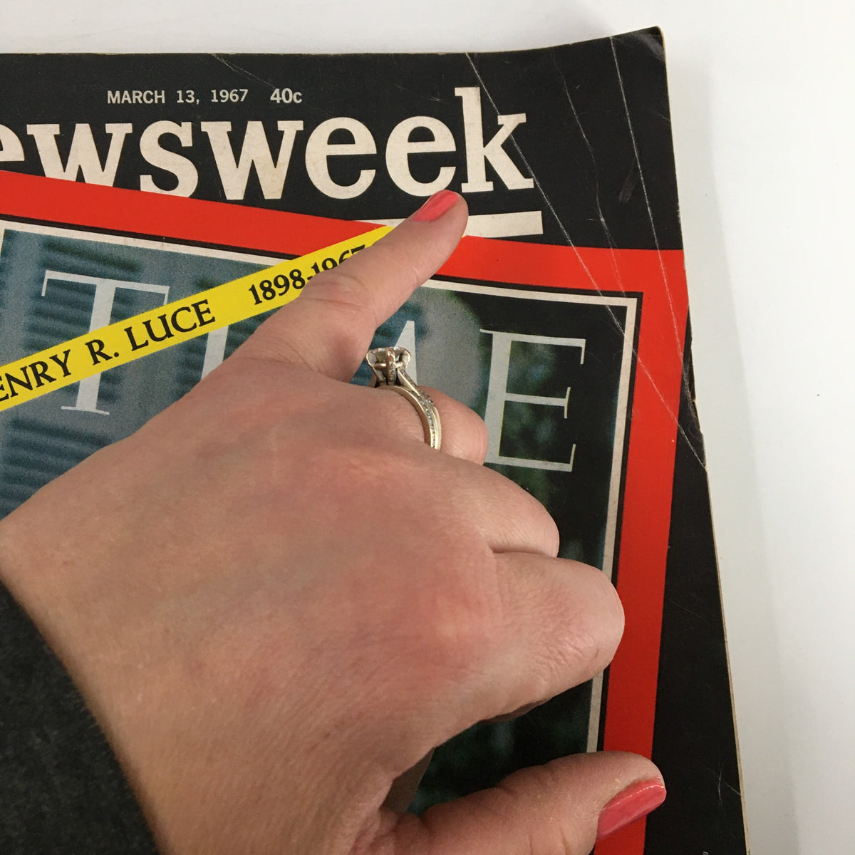 A hand pointing at the title of the VTG Newsweek Magazine March 13, 1967. The cover shows the keywords 'Henry R. Luce 1898-1967' in a prominent yellow band, emphasizing the magazine's historical significance.