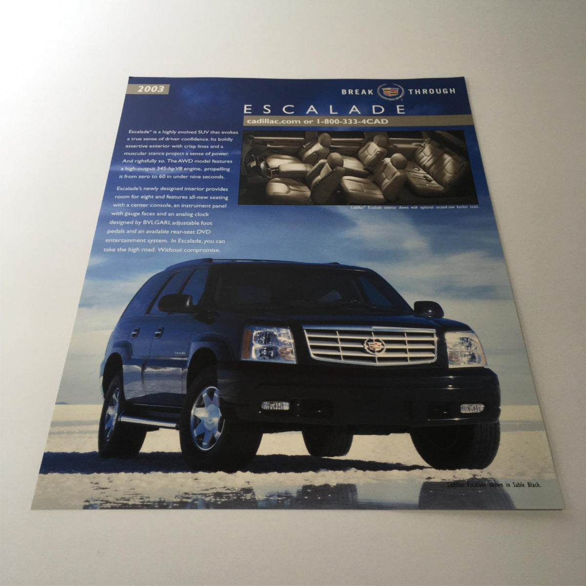 2003 Cadillac Escalade Break Through SUV specifications brochure showcasing the vehicle in front of a scenic background, highlighting its design and performance features.