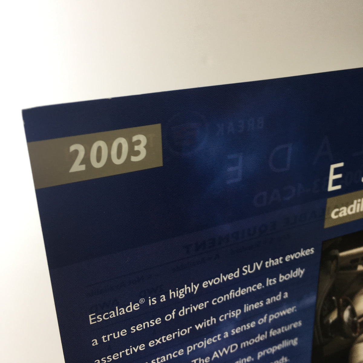 Close-up of the 2003 Cadillac Escalade Break Through SUV brochure header, featuring the year '2003' and branding details, emphasizing its high-quality design.