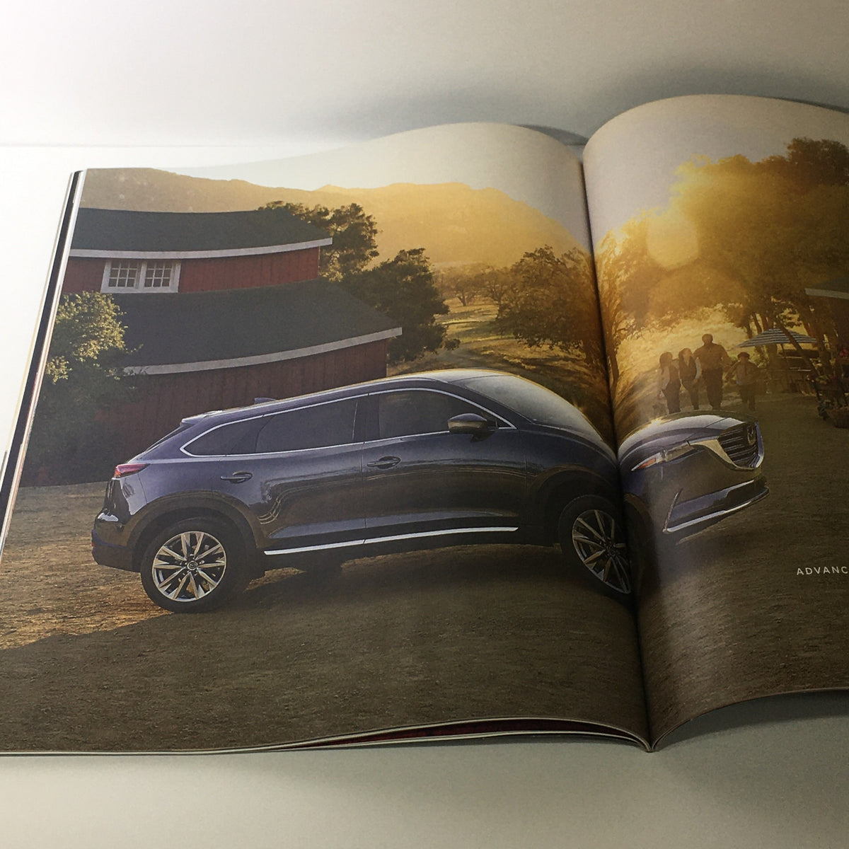 Spring 2016 Mazda RX-Vision CX-9 Debuts dealership car catalog brochure illustrating the Mazda CX-9 parked in a scenic rural location, emphasizing luxury and style.