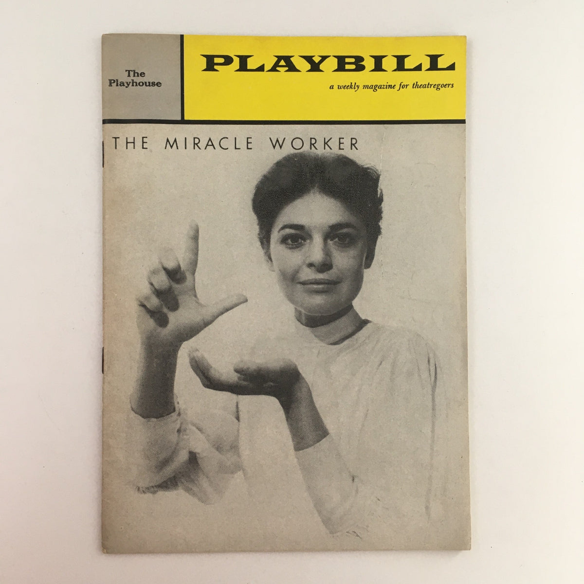 1960 Playbill for The Miracle Worker, featuring a black and white cover image of a woman displaying a gesture, showcasing vintage theater memorabilia from The Playhouse.