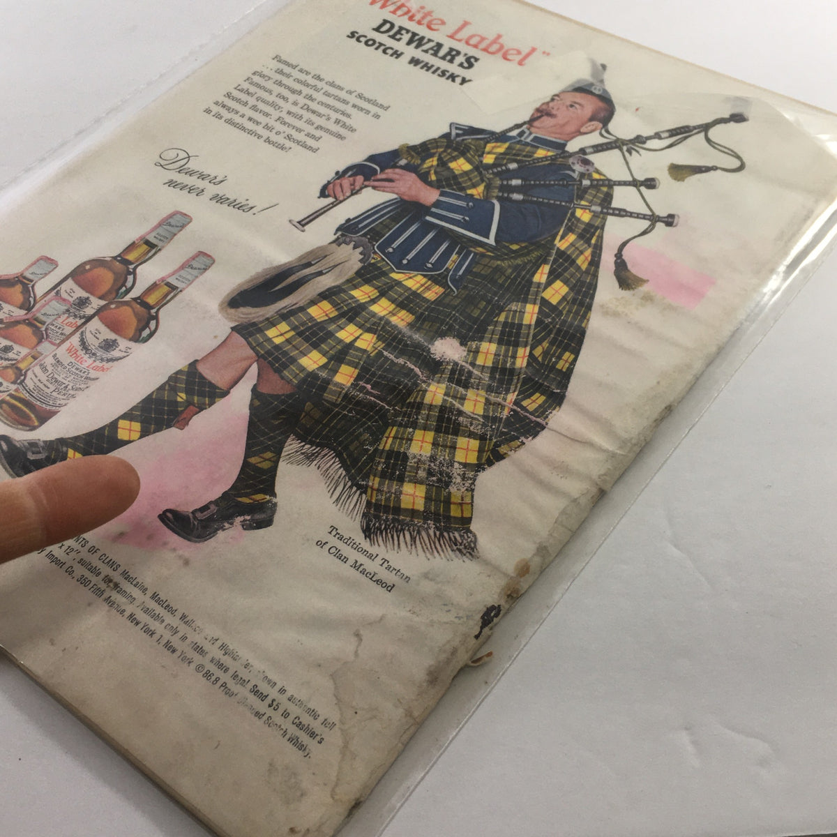Vintage advertisement for Dewar's Scotch Whisky featuring a bagpiper in traditional attire, promoting the brand and its rich heritage. Contextualizes the popular culture of 1962, related to Sports Illustrated: April 30, 1962 - The Players With Magic Luis Aparicio.