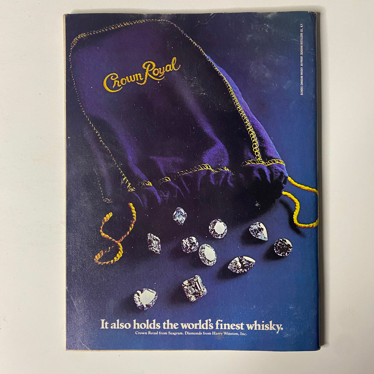 Cover of Forbes Magazine, February 15, 1982, featuring Crown Royal whisky advertisement. The image showcases a luxurious purple bag with the Crown Royal logo, surrounded by sparkling gems, highlighting the tagline 'It also holds the world's finest whisky.'