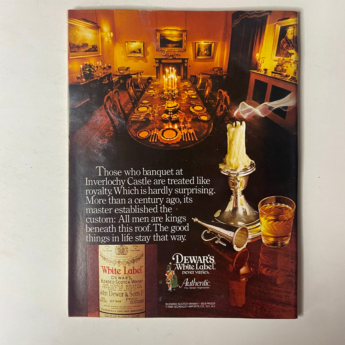 A vintage advertisement from Forbes Magazine January 16, 1984, promoting Dewar's White Label whisky, showcasing elegant dining with a royal atmosphere.