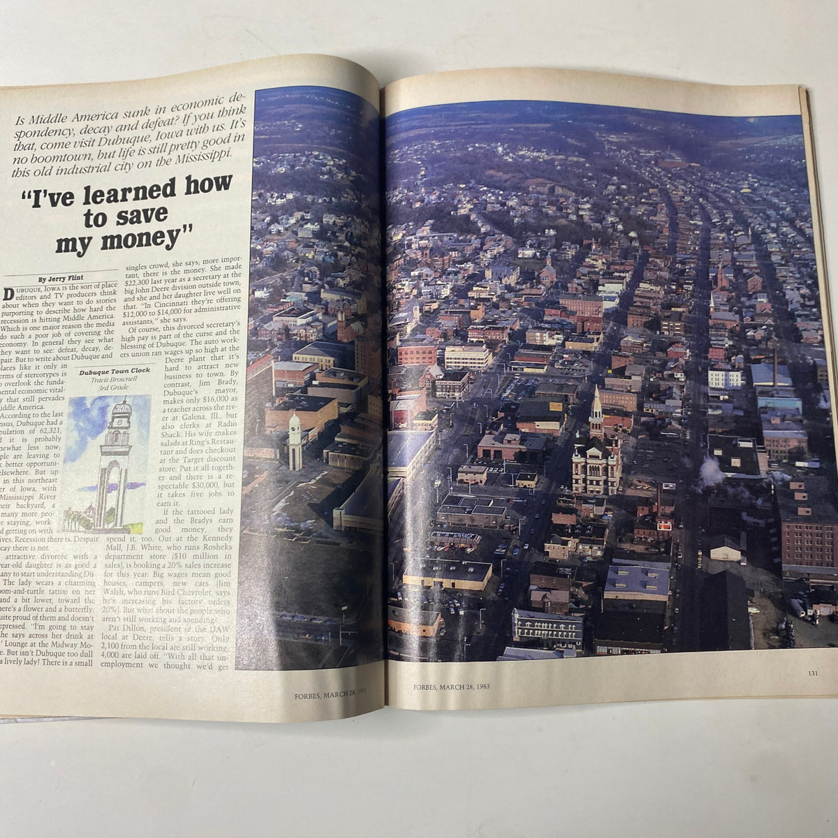Page spread from Forbes Magazine dated March 28, 1983, displaying an aerial view of Dubuque, Iowa, accompanied by an article discussing economic resilience in Middle America and the city's historical significance along the Mississippi River.