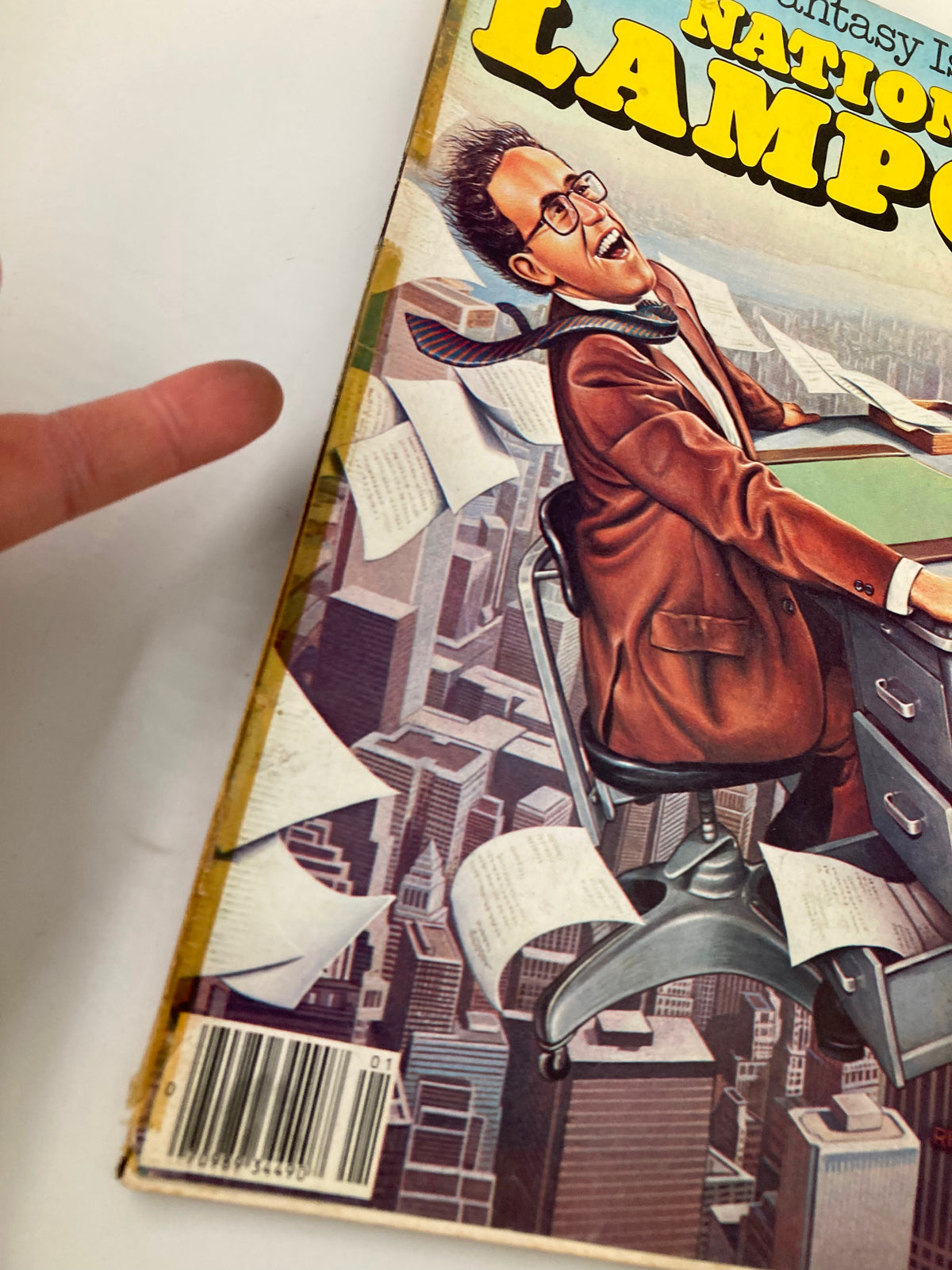 Detail of the cover art from National Lampoon Humor Magazine January 1980, showcasing a joyful character at a desk, emphasizing the magazine's fun and entertaining design.